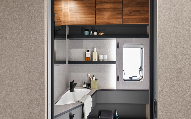 Integrated shelves and many storage compartments make the bathroom a small space miracle.