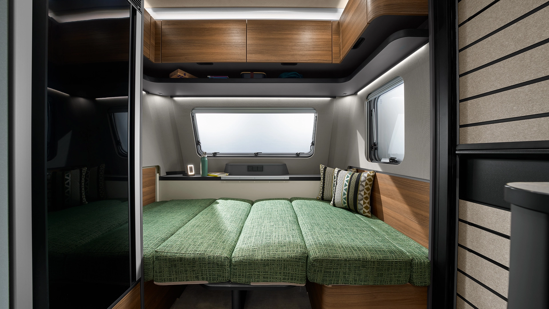 Seating group with green cushions converted to lying area