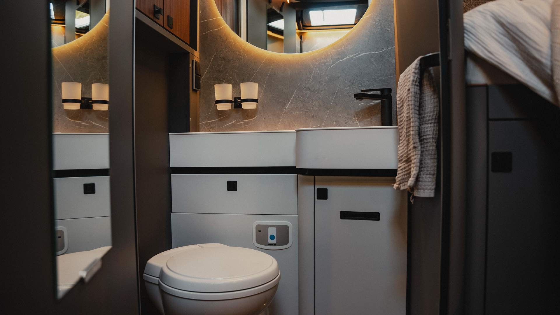 The stylish bathroom offers a compact toilet that impresses with its elegant design and harmonious integration into the room. Experience luxury and comfort, perfectly implemented in a small space, for sophisticated travel needs.