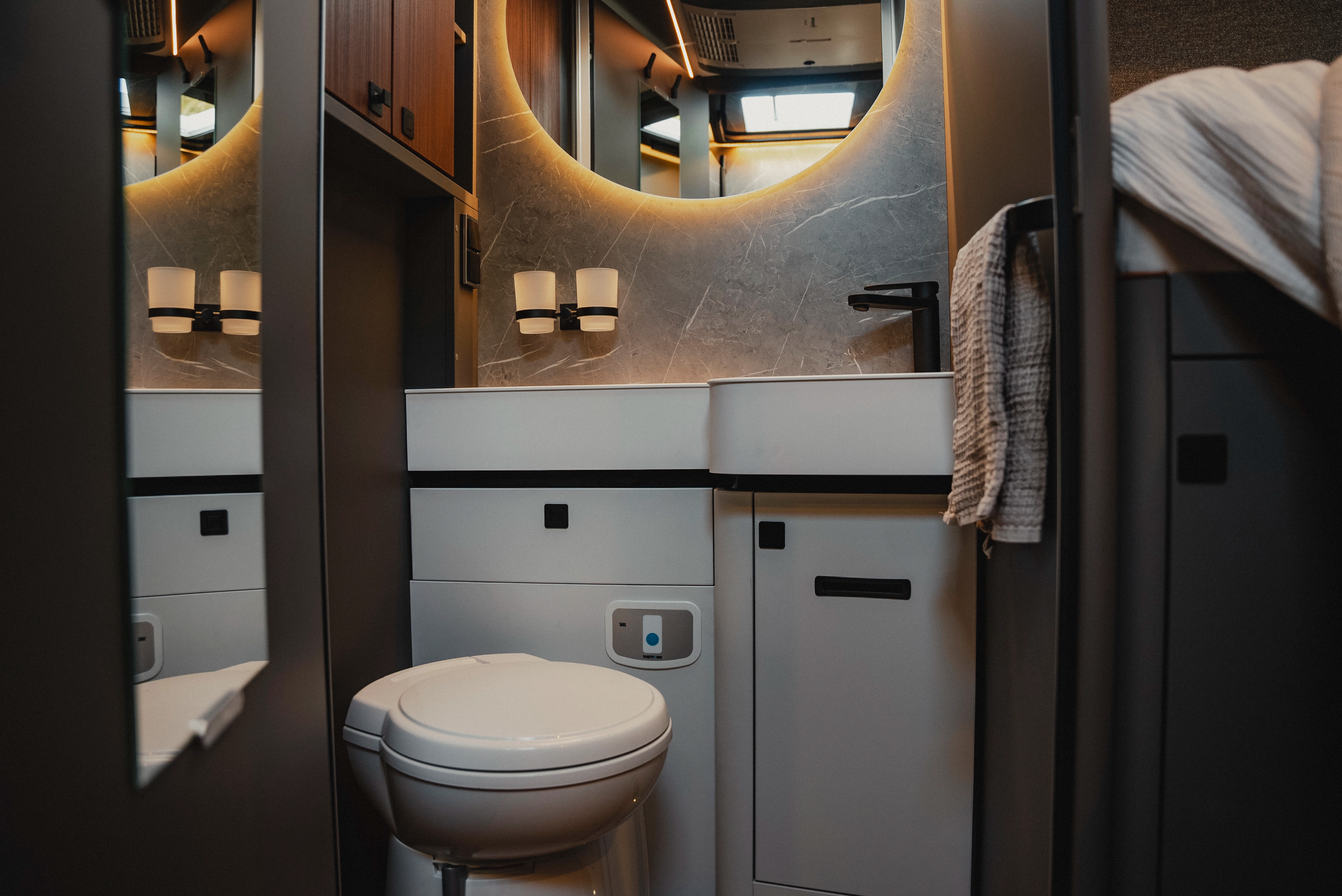 The stylish bathroom offers a compact toilet that impresses with its elegant design and harmonious integration into the room. Experience luxury and comfort, perfectly implemented in a small space, for sophisticated travel needs.