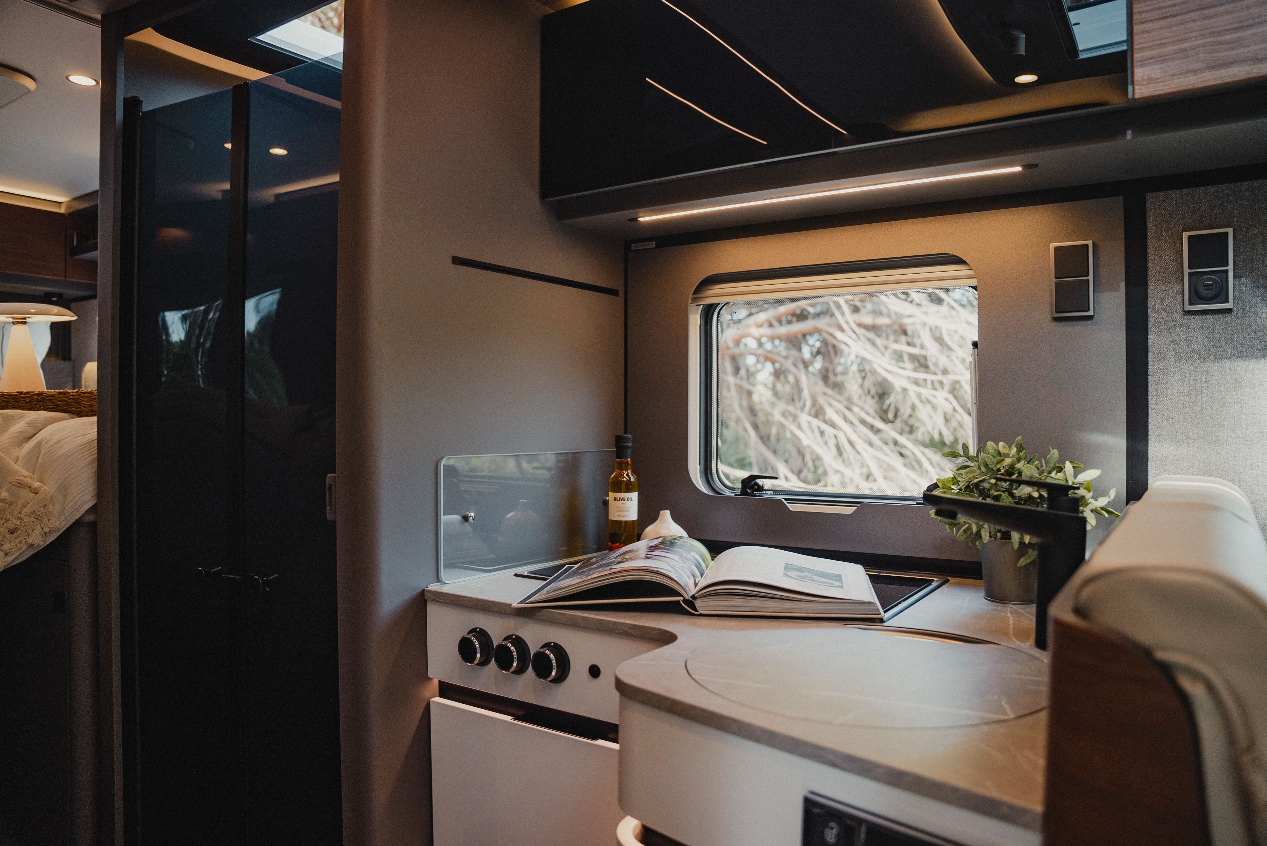 Cooking with a view: Thanks to the high-quality kitchen wall cladding, even the window becomes a design element. This combination of stylish design and natural panorama makes travelling a pure joy.