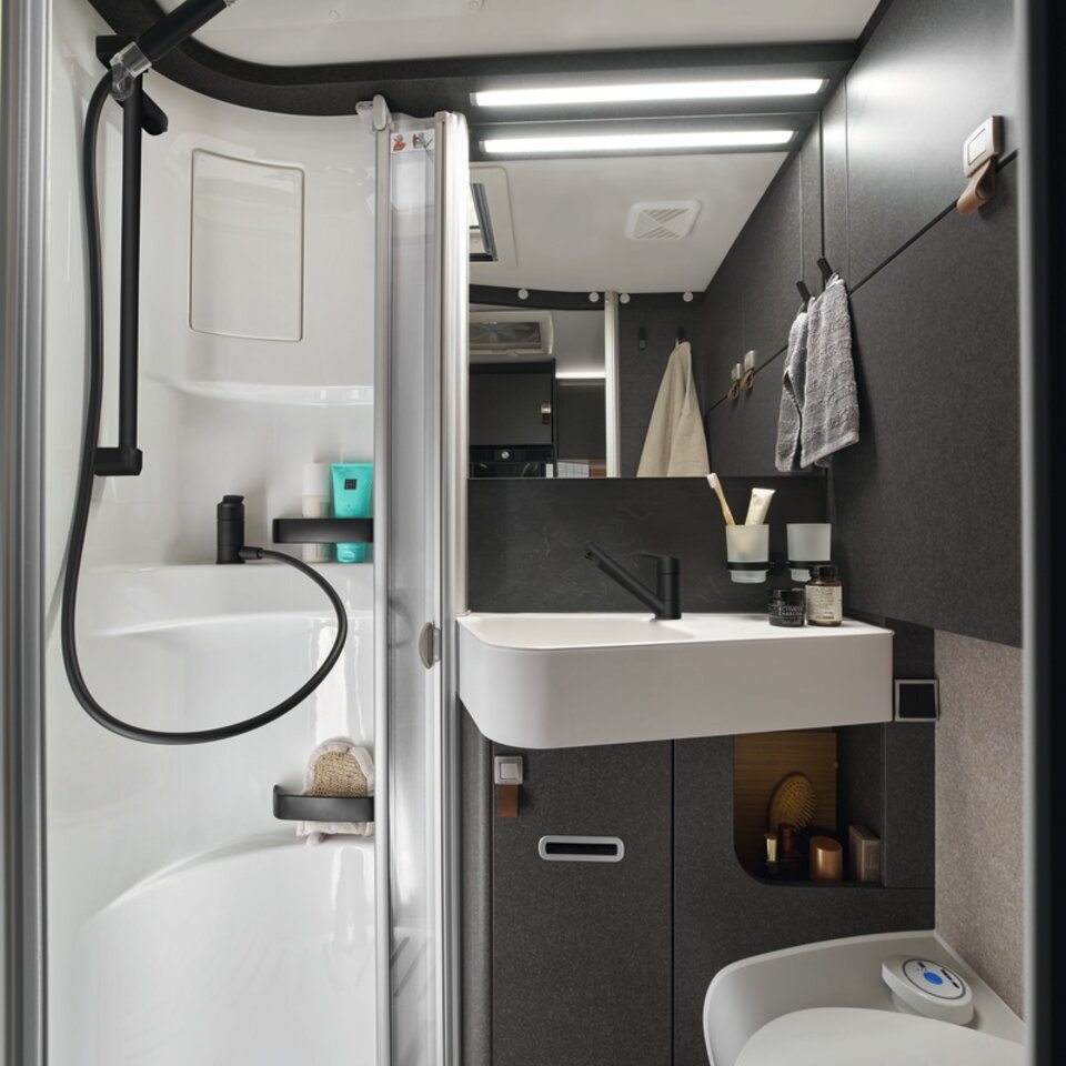 Above the shower in the bathroom of the HYMER ML-T in the Native Bamboo style world is a practical clothes rack. Above it is a skylight.