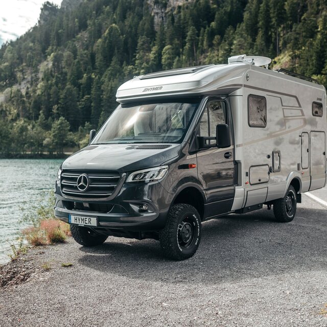 Le HYMER ML-T est vu de face, stationné devant un lac de montagne.