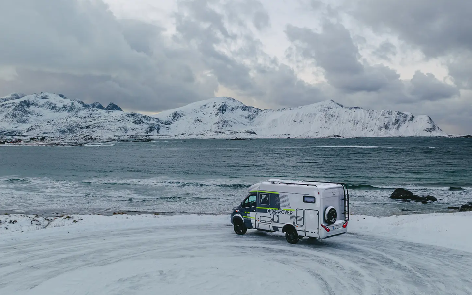 HYMER ML-T 570 CrossOver parked at a viewpoint, the sea and snowy mountains in the background
