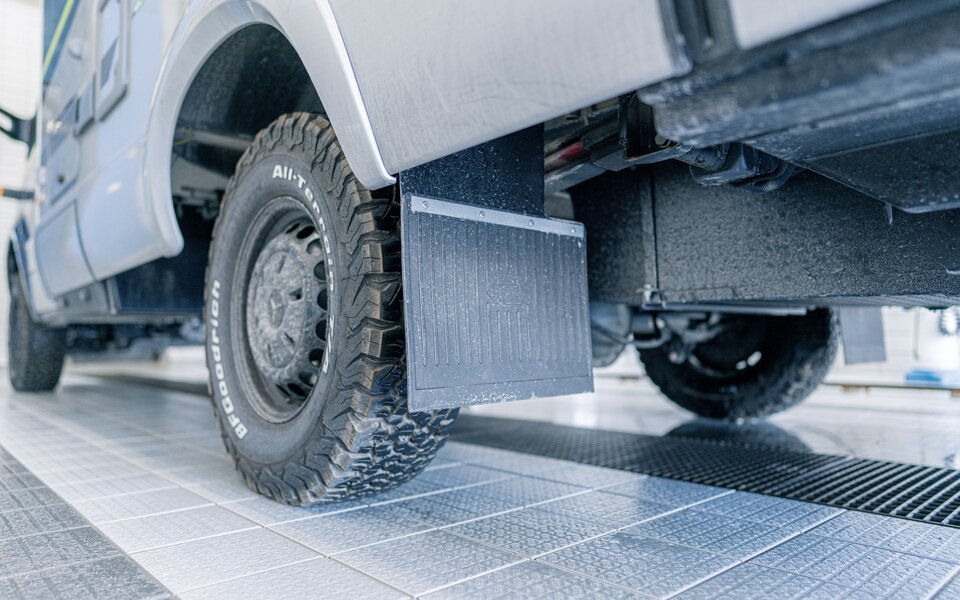 View of the underbody, spoiler and tires of the HYMER motorhome in the wash hall