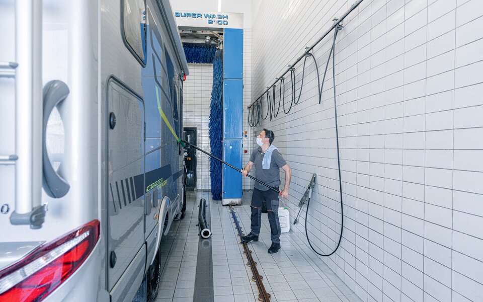 Basic cleaning of the outside wall of the HYMER motorhome using a jet wash in the wash hall